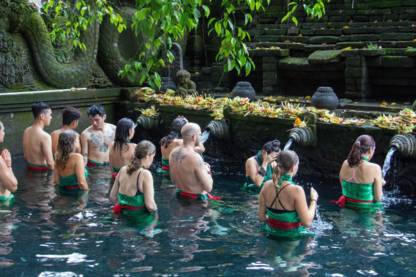 A group of tourists are doing purification ceremony in Tirta Empul temple